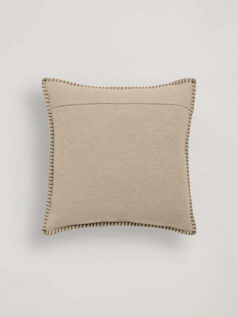 A square beige throw pillow with contrast brown stitching around the edges, shown against a light gray background.